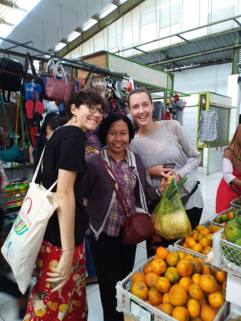 International students shopping at traditional market in Yogyakarta with local host